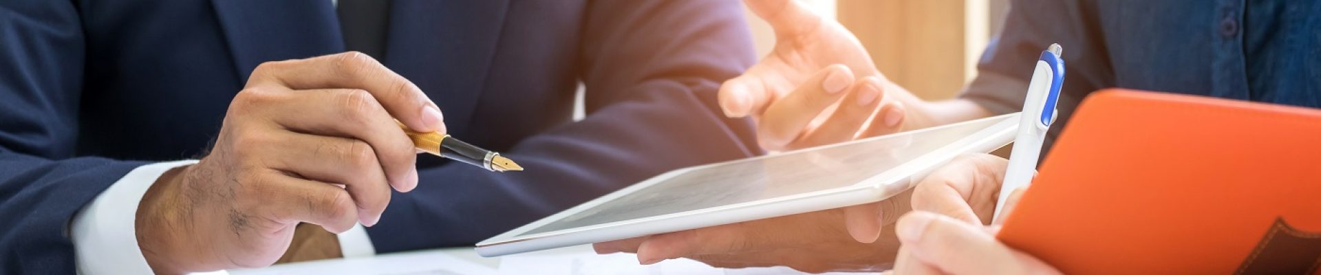 Executives listening to presentations from employees,Office worker is presenting job with tablet and secretary is taking notes.